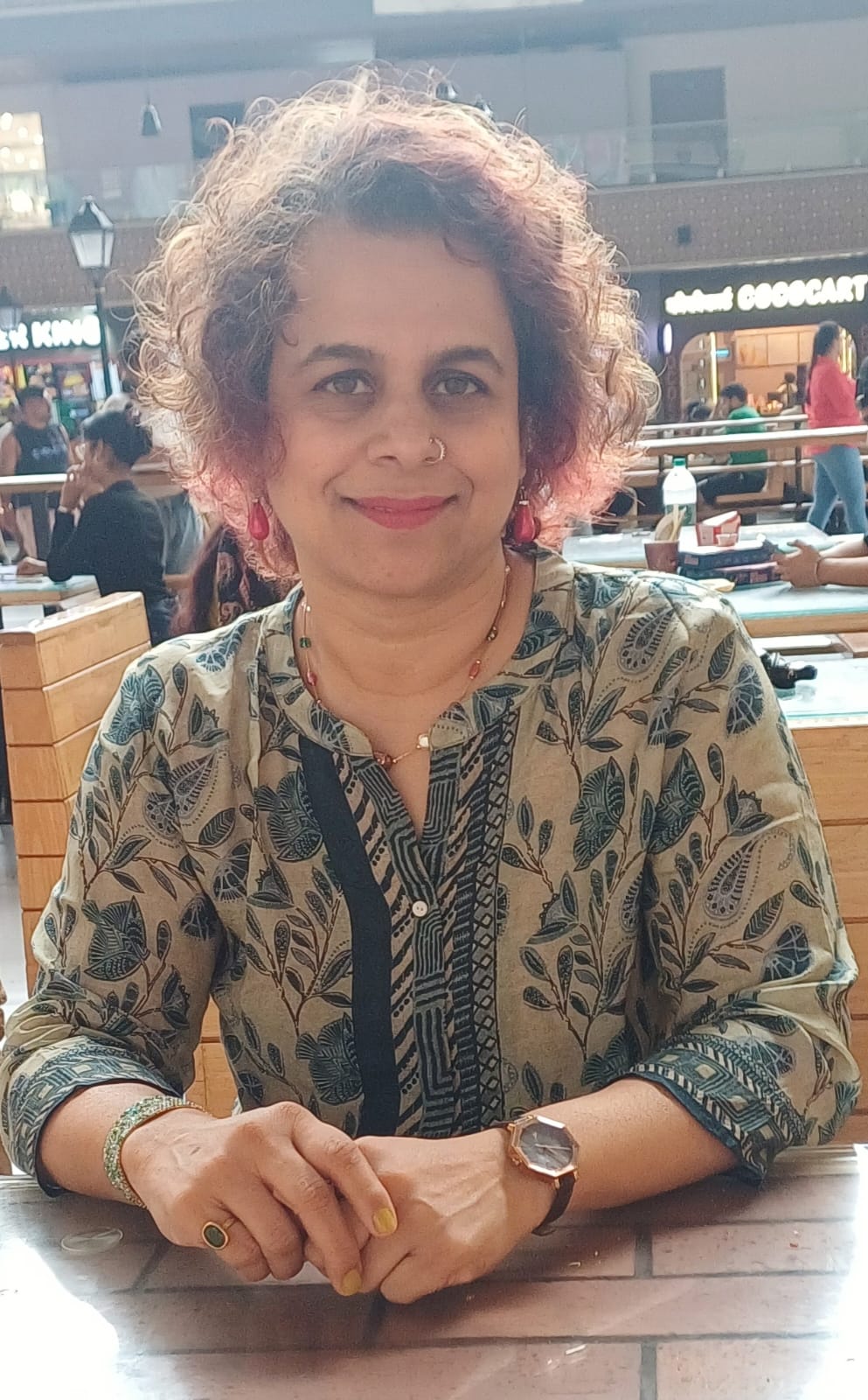 Shalaka smiling, seated at a table